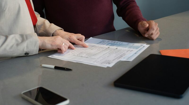 To personer gennemgår dokumenter og budget ved et bord